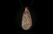 Aged bronze pendant featuring an embossed bald eagle, 'AMERICA' text, and flag details, worn on a black braided cord.