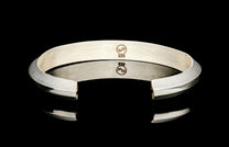 Silver cuff bracelet by WH with a textured exterior and polished interior, featuring a visible 925 stamp.