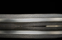 Jewelry item with dark, dimpled texture and polished silver metal bands.