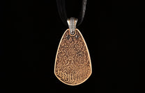Bronze teardrop pendant with intricate embossed leaves, vines, and "Jekyll + Hyde" text, on a black cord.