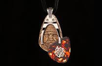 Bronze and silver-toned pendant by William Henry, featuring a carved bearded man's face and holding a tortoiseshell guitar pick.