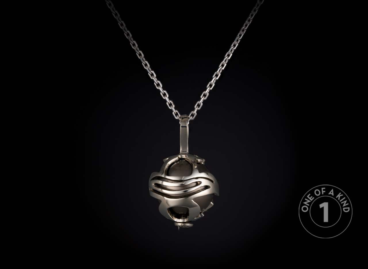Silver-toned necklace featuring a spherical pendant with an abstract open-cage design encasing a dark, polished orb.