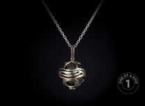 Silver-toned necklace featuring a spherical pendant with an abstract open-cage design encasing a dark, polished orb.