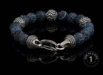 Dark blue cracked agate beaded bracelet with ornate silver-toned accents, a decorative clasp engraved 'William Henry', and reflected on a black surface.