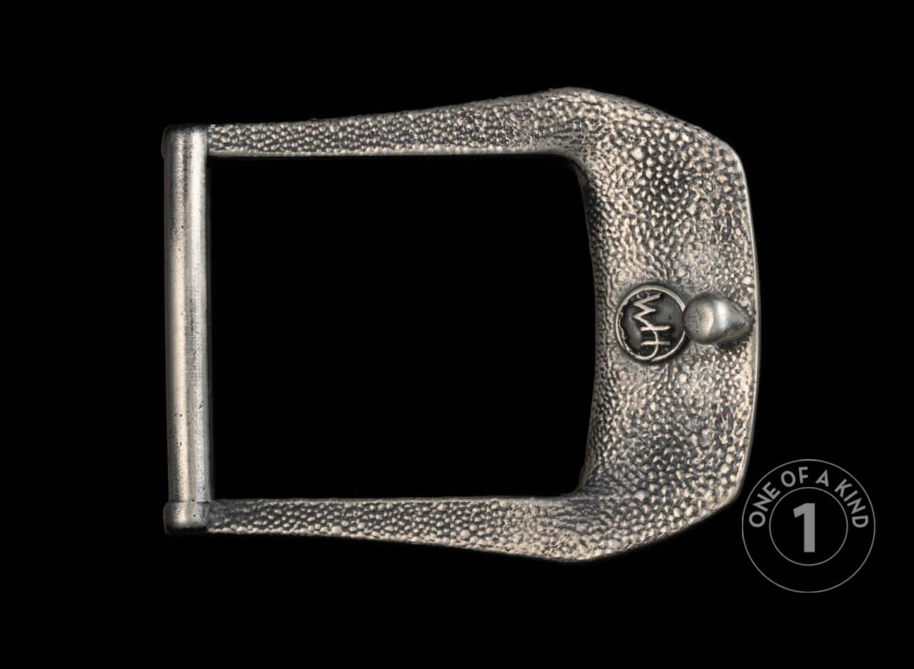 Silver-toned D-ring belt buckle with a hammered texture, a 'wh' initial emblem, and a small stud.