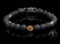 Matte black beaded bracelet with ornate silver-toned and gold-toned rose spacer beads, featuring a patterned silver clasp.