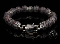 Beaded bracelet featuring dark grey patterned stone beads, decorative silver-toned spacers, and a unique clasp on black.