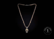 Translucent grey beaded necklace with a detailed silver skull pendant and gold accents.