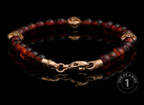 Dark red and brown beaded bracelet with ornate gold-tone metal spacer beads and lobster clasp.