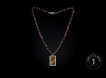 Multi-colored beaded necklace with a rectangular silver pendant featuring striped brown and orange inlay, laid flat.