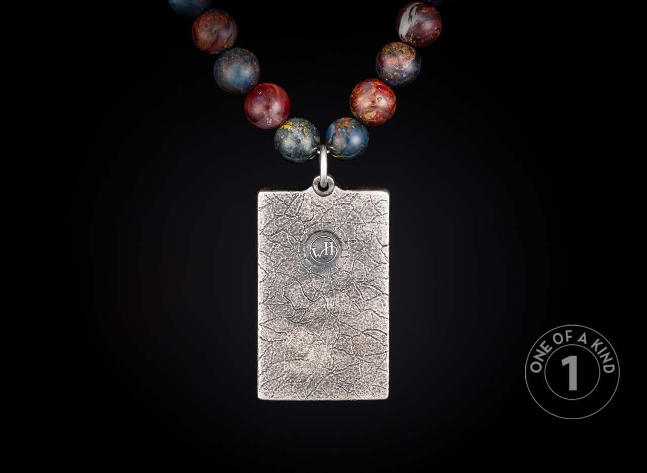 Silver-toned rectangular pendant with textured finish and "WH" initials, hanging from a colorful beaded necklace.