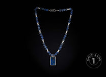 Blue beaded necklace with silver spacers, a silver clasp, and a rectangular blue stone pendant in a silver frame.