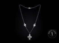 Black beaded necklace featuring a detailed silver-toned cross pendant and two decorative metal connectors.