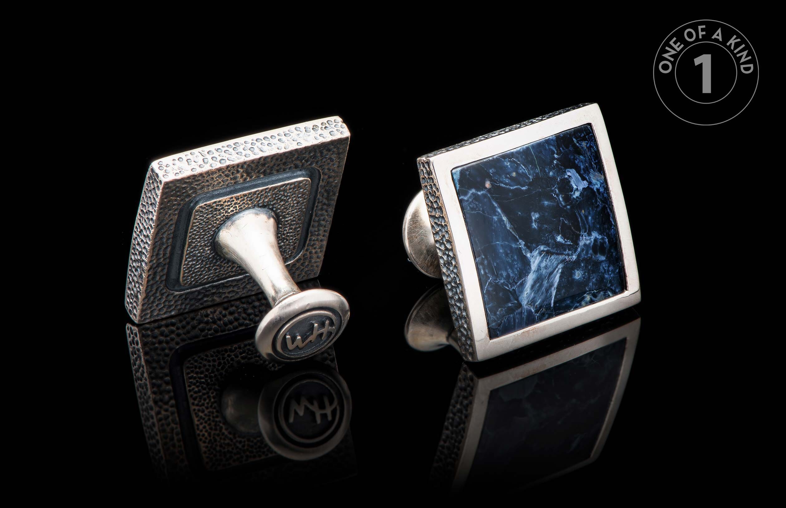 Square cufflinks with a dark blue marbled stone face in silver, and a textured dark metal back featuring an engraved 'WH'.