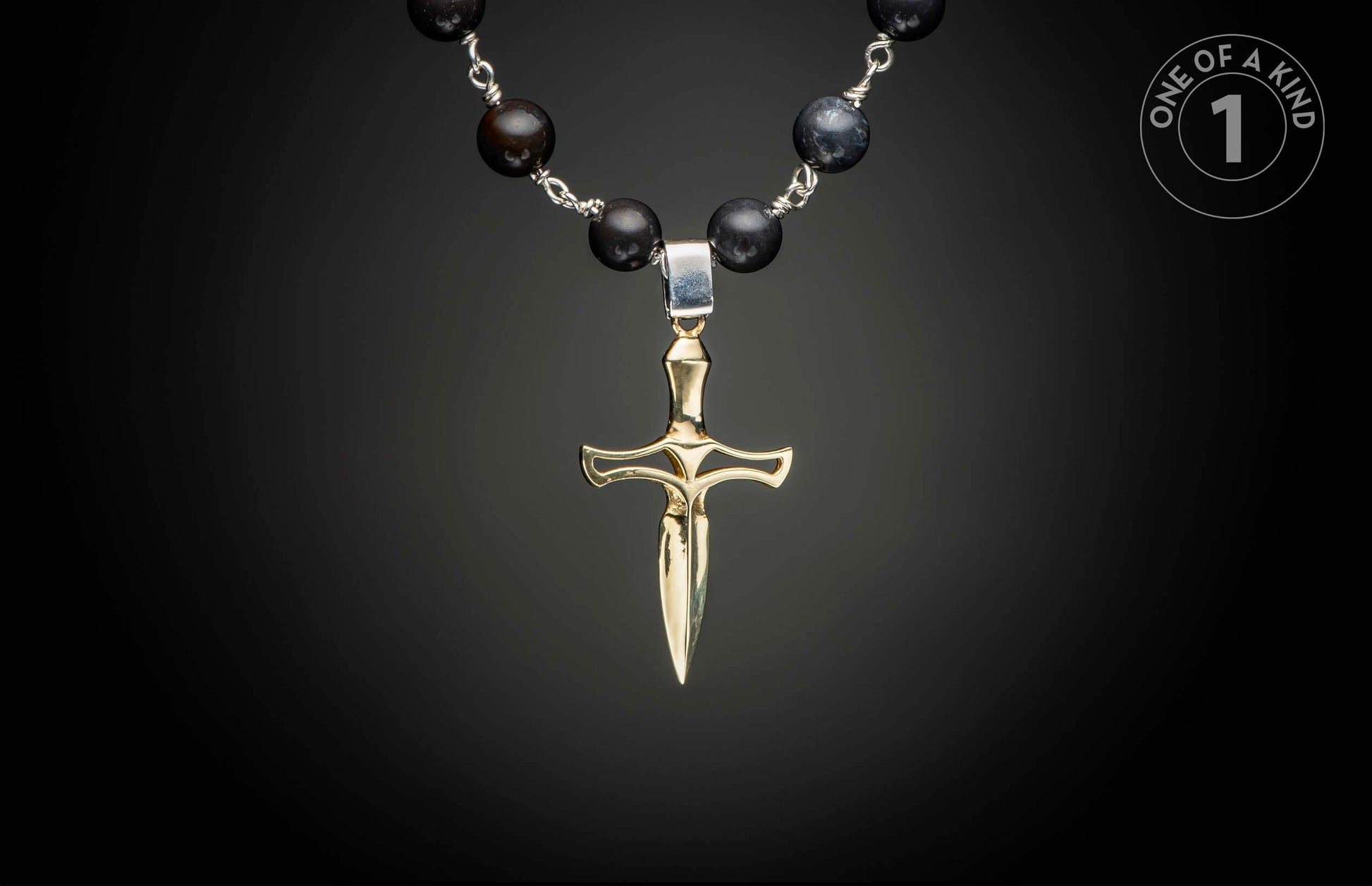 Gold-toned dagger pendant on a dark beaded necklace with silver wire connections.