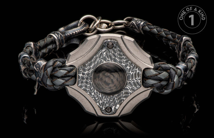 Front view of a braided black and grey leather bracelet with a textured grey metal centerpiece and a dark circular inlay.