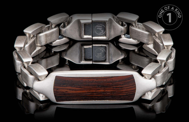 Silver bracelet with dark wood inlay, featuring interlocking links and a reflective black background.