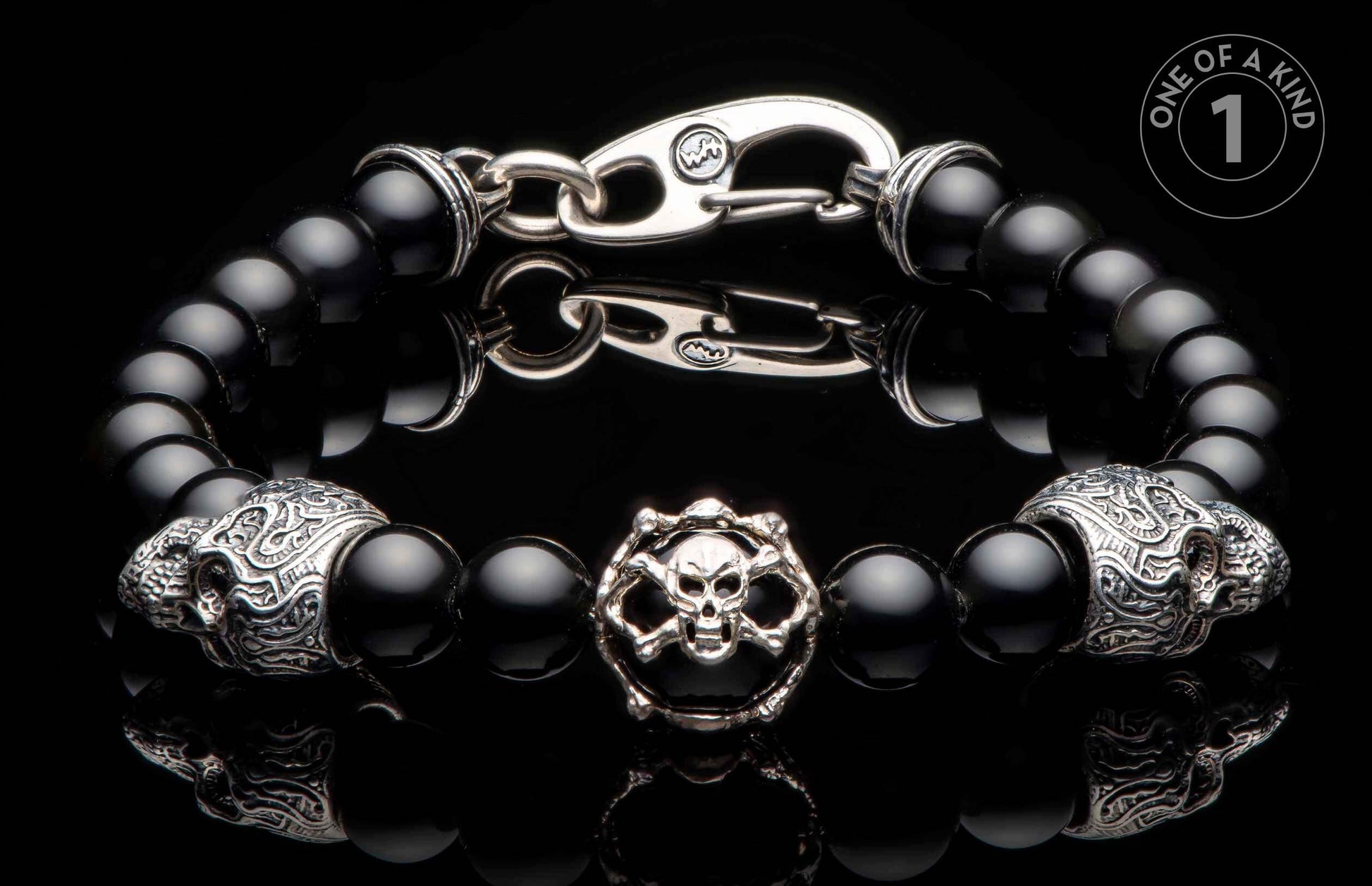 Black onyx beaded bracelet with a silver-toned skull and crossbones charm, two ornate skull beads, and a hook clasp.