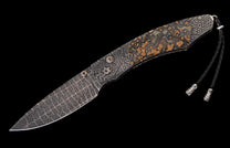 Folding knife with patterned Damascus blade and handle, mottled natural stone scales, decorative hardware, and braided leather lanyard.