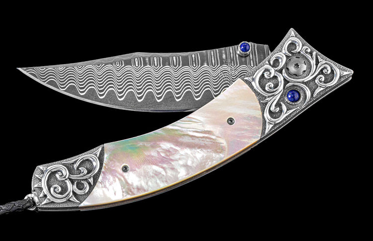 One of a Kind Custom William Henry Knife featuring Mother of pearl scales, Hand-carved sterling silver, Lapis Lazuli gemstones, and a hand forged Damascus steel blade.