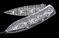 One of a kind custom William Henry Knife with hand-forged Damascus steel, hand-carved sterling silver, and sapphire. 