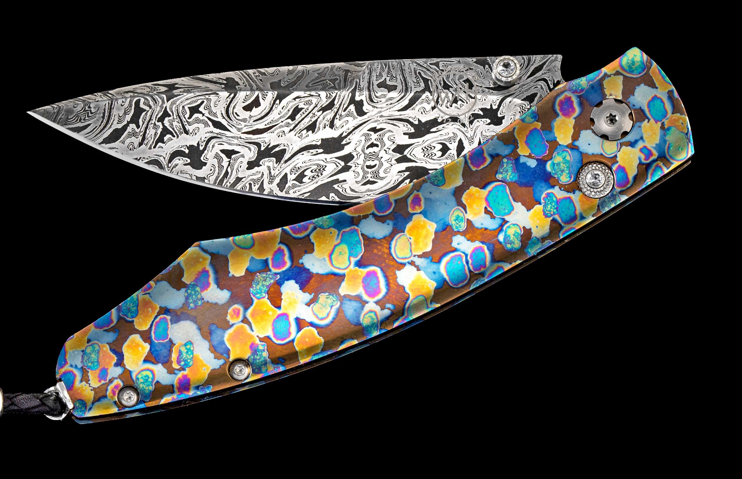 One of a kind William Henry custom knife with hand forged Damascus steel, Laser-colored titanium, and white topaz gemstones.