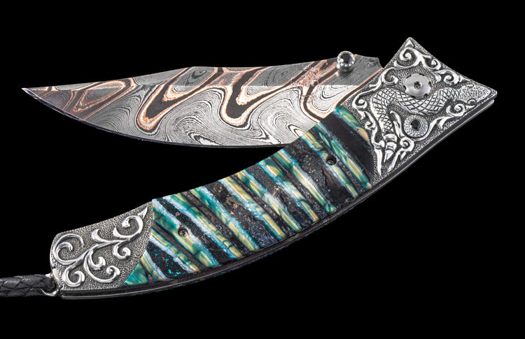 Folding knife with a wavy silver and copper damascus blade, intricate silver handle with a dragon motif, and iridescent blue-green and gold scales.
