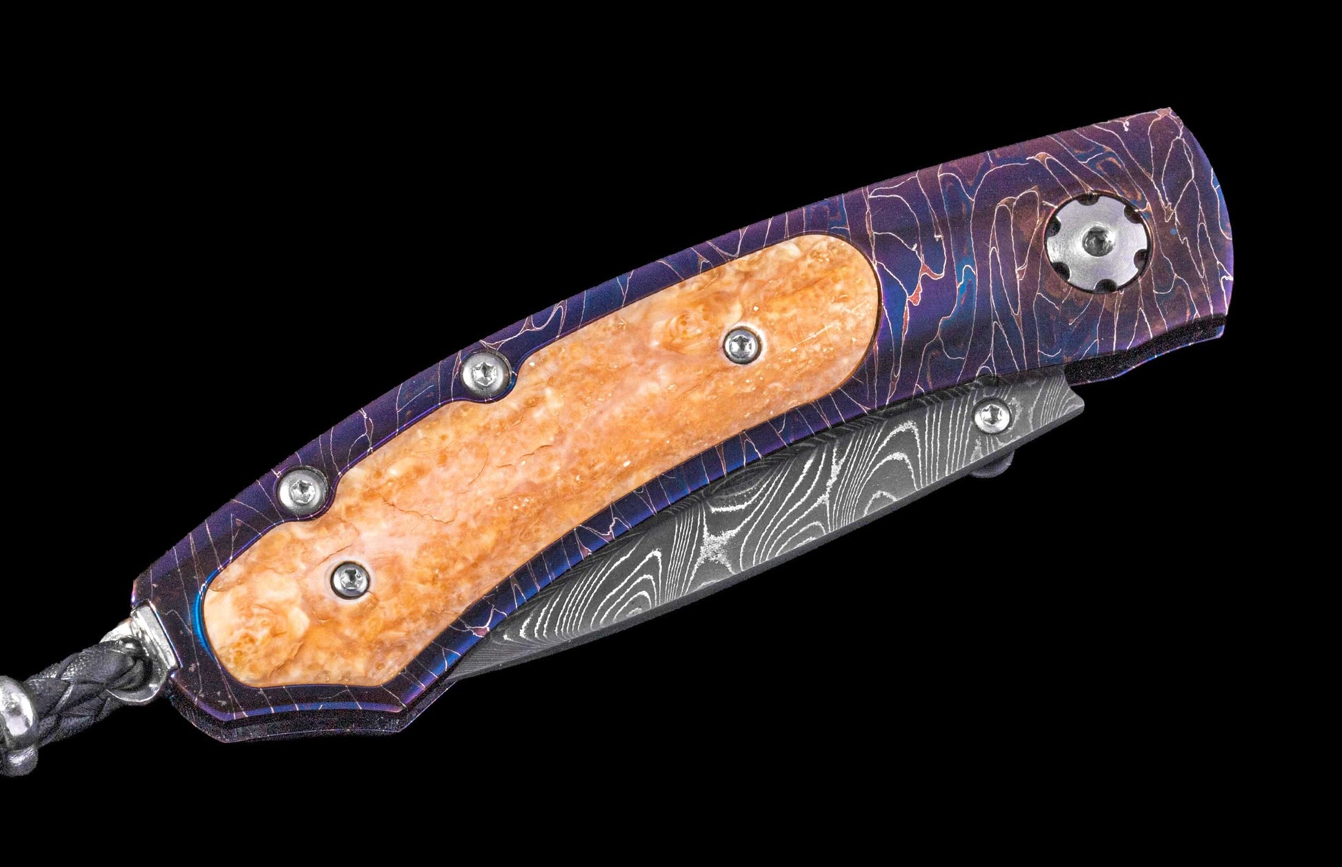 Folded knife with marbled orange handle inserts, a purple patterned frame, Damascus blade, and a braided black lanyard.