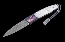 A folding knife with a swirling Damascus steel blade, iridescent purple and blue textured handle with white mother-of-pearl dragon inlay, and a black braided leather lanyard.