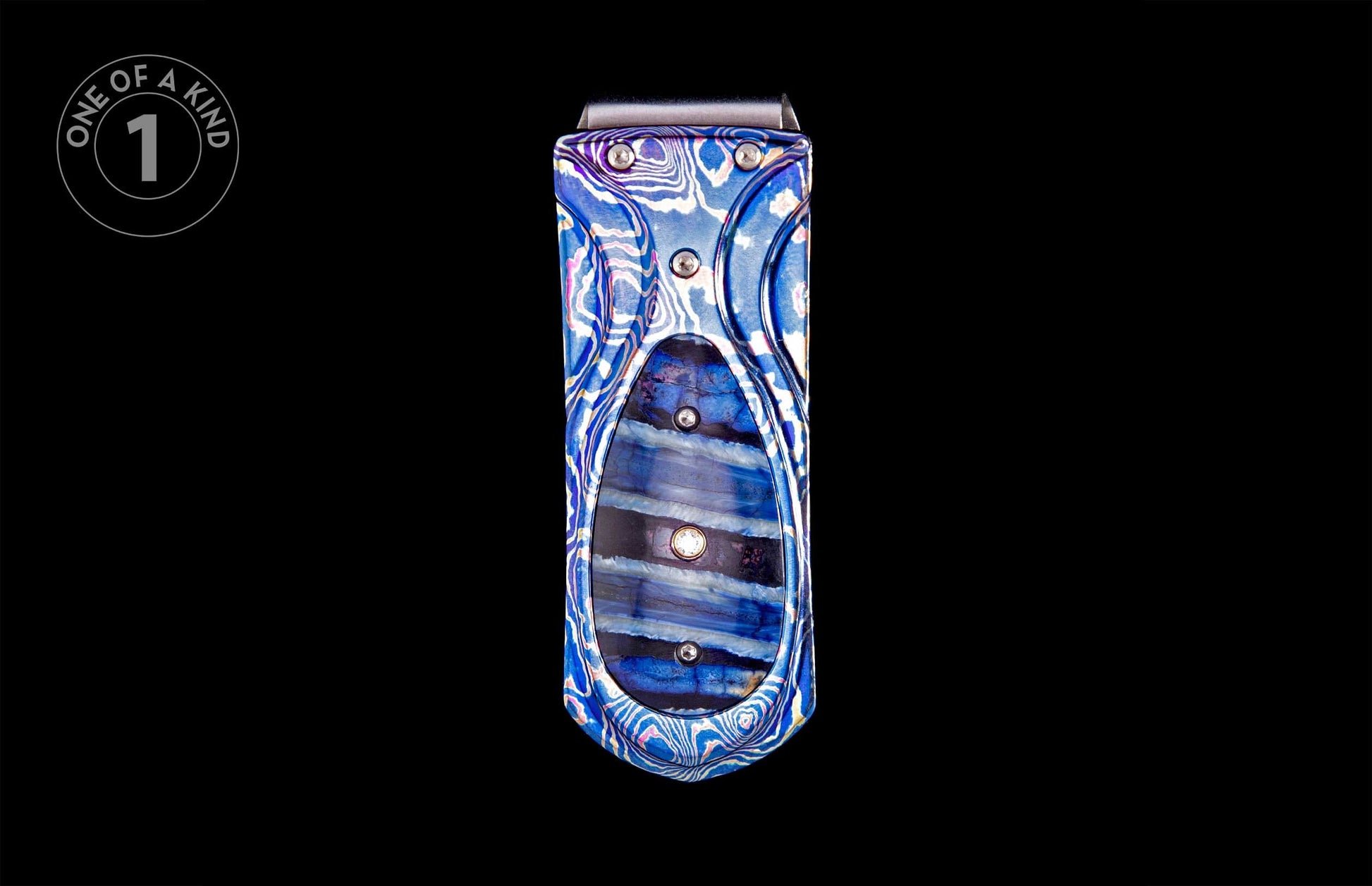 Blue patterned money clip featuring swirled blue and white metal and a central inlay of horizontally striped blue and black stone with silver fasteners.
