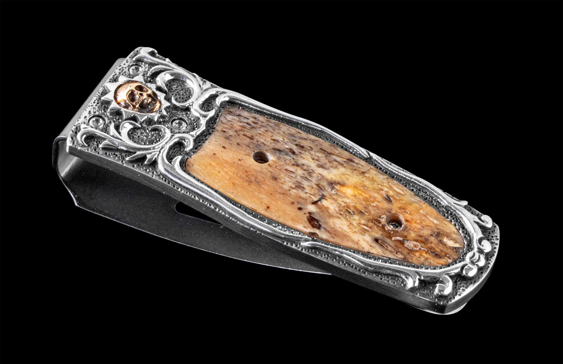 Handcrafted Money Clip from William Henry featuring hand-carved sterling silver inlaid with fossil Woolly Mammoth bone. The clip is machined and blast-polished from tempered stainless steel, with a beautiful engraving bright cut against the matte-finished