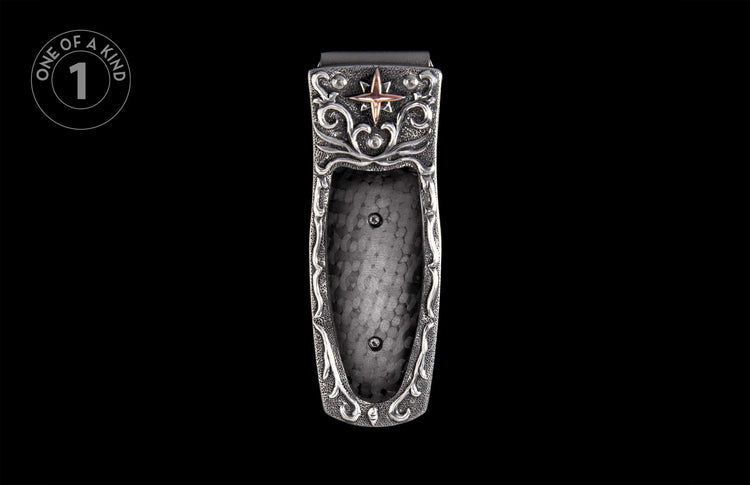 Ornate silver-toned money clip with a prominent copper star, intricate scrollwork, and textured metal finish.