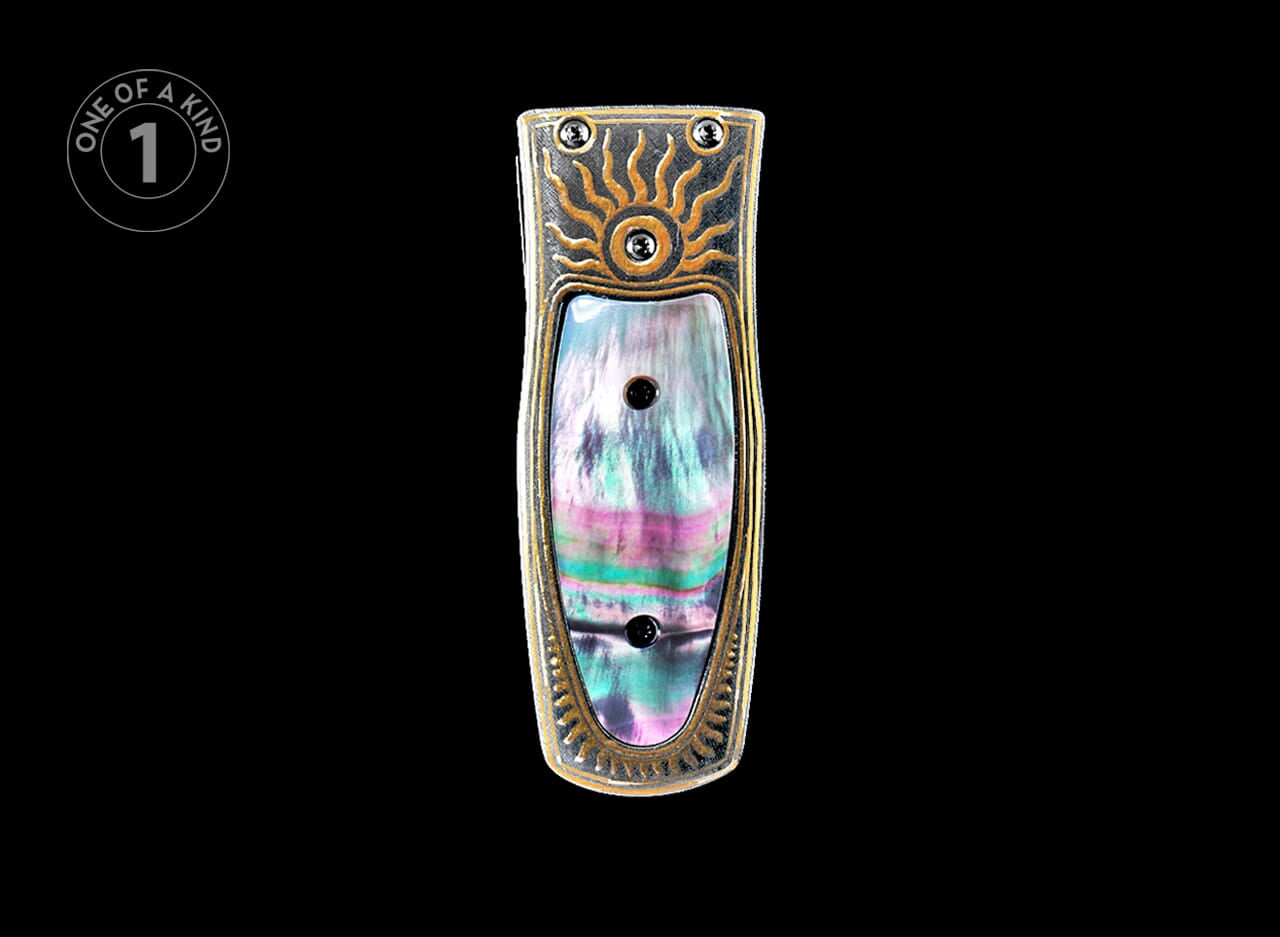 A silver-toned money clip with a gold sunburst design and iridescent rainbow fluorite inlay.