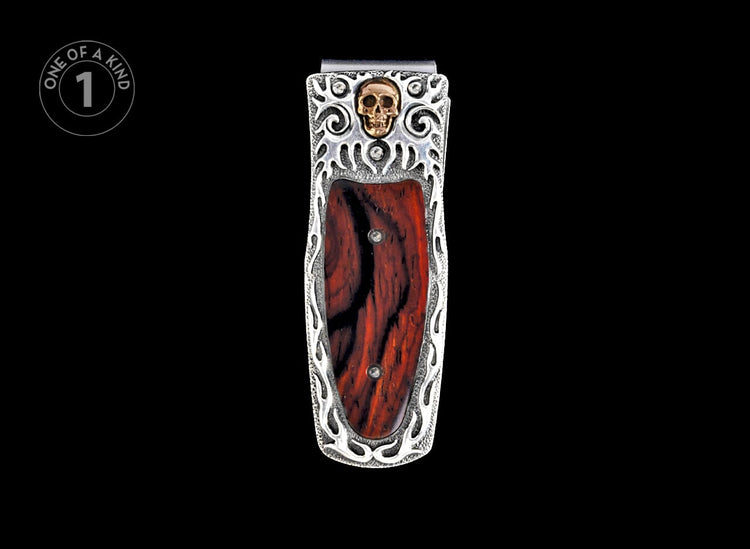Silver-toned money clip with dark red wood inlay, featuring a gold skull and ornate silver frame.