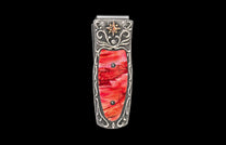 Silver money clip with a vibrant red inlay, adorned with intricate scrollwork, a gold star, and clear stones.