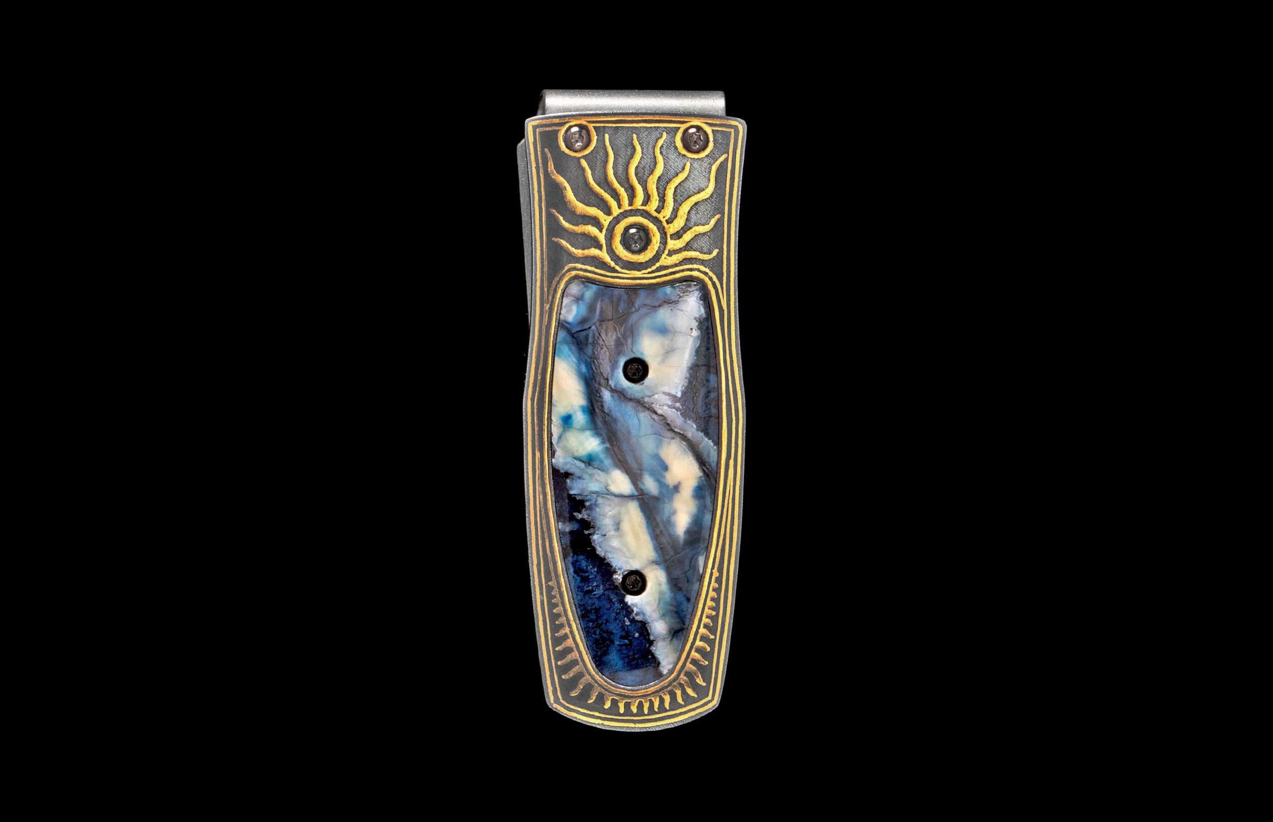 Silver and dark metal money clip with a blue and white marbled inlay, gold sunburst, and patterned trim.