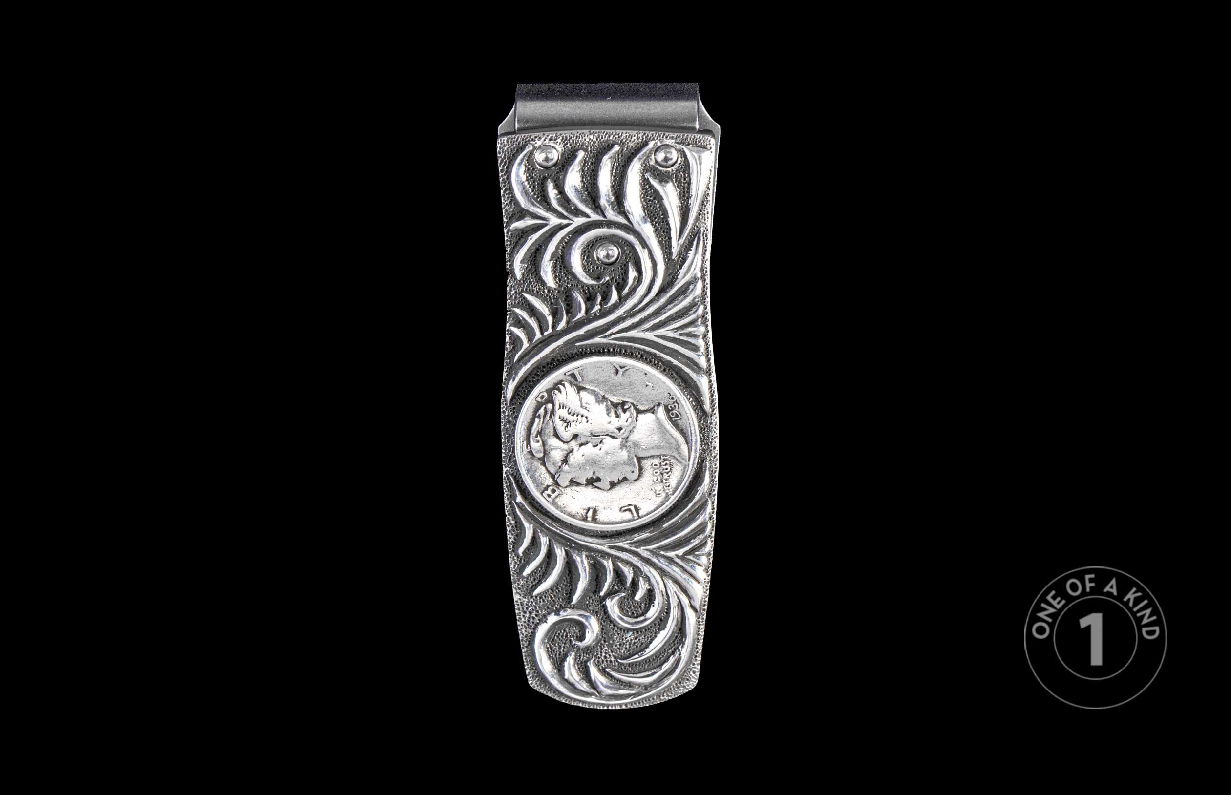 Silver money clip with ornate scrollwork and an embedded 1936 Mercury dime, centered on a black background.