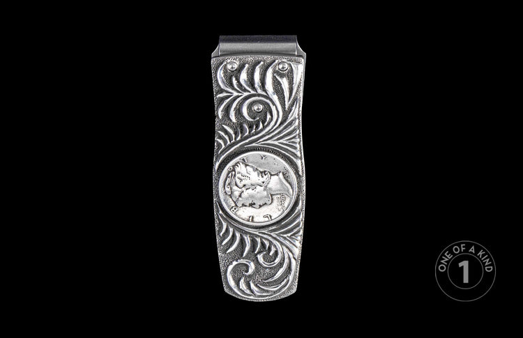 Silver money clip with ornate scrollwork and an embedded 1936 Mercury dime, centered on a black background.