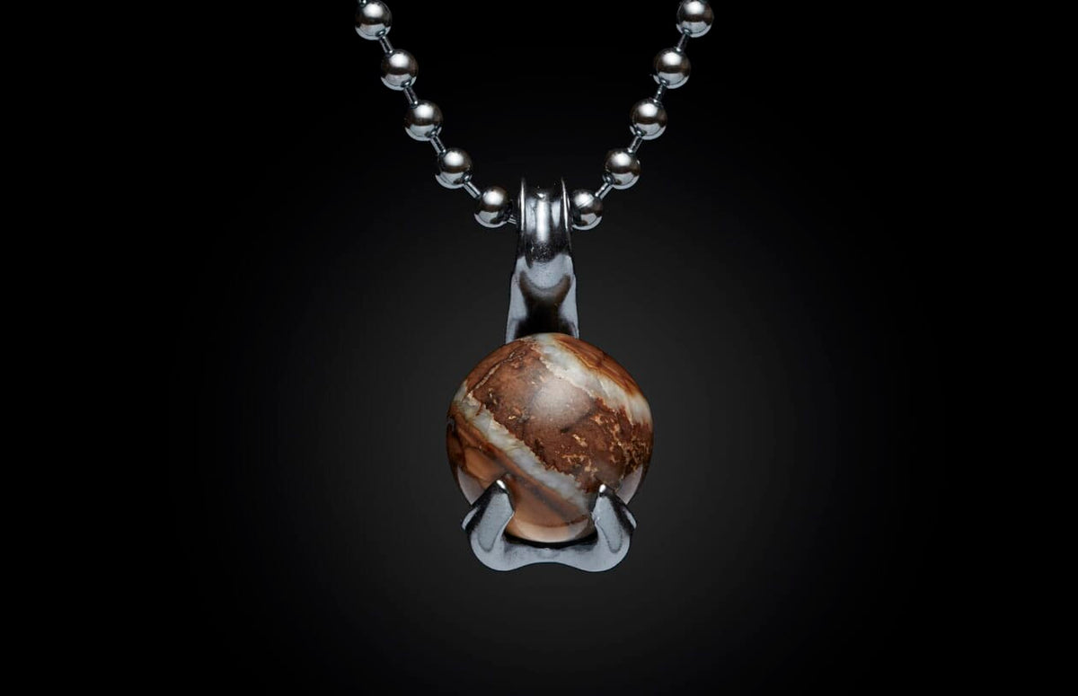 Silver ball chain necklace with a round, swirling brown and white stone pendant held by a metallic claw setting.