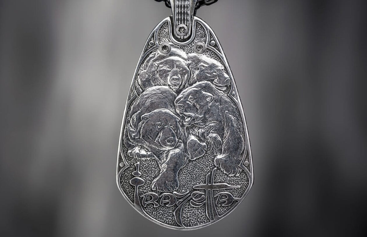 Silver metal pendant featuring four detailed relief bears, a textured background, and stylized "RAVE" text with a cross.