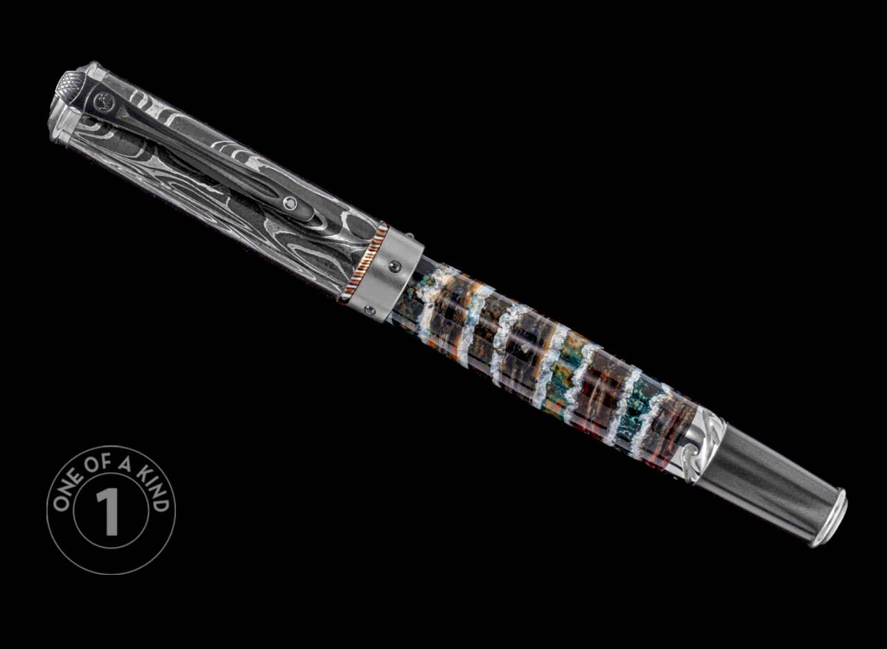 One of a Kind custom pen from William Henry featuring a fossil mammoth tooth barrel, hand forged Damascus steel cap, Spinel gemstone, and titanium accents.