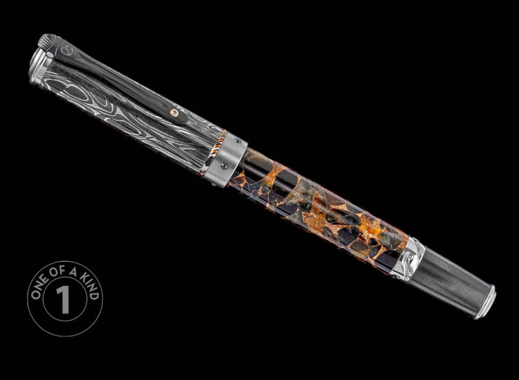 One of a Kind pen from William Henry featuring a black & yellow tiger eye barrel, hand forged Damascus steel cap, white topaz gemstone, and titanium accents.