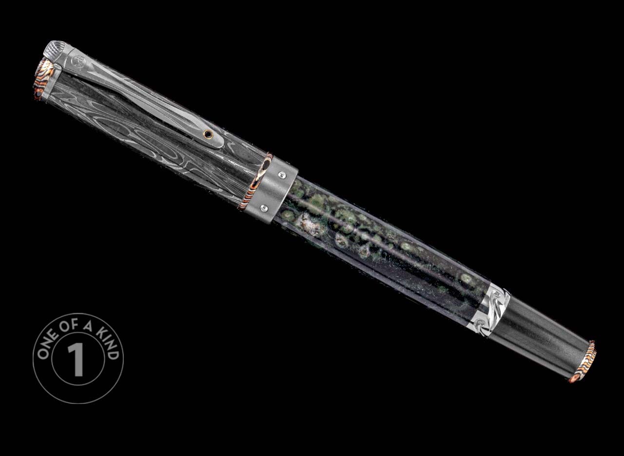 One of a Kind pen from William Henry featuring a moss agate barrel, hand forged Damascus cap, spinel gemstone, and Mokume Gane accents.