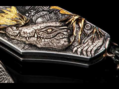 This engraving by Vlastik Petak is a story of the Okavango Delta. This VERY complex and elaborate engraving features a full palette of engraving techniques: photo realistic bulino work for the hippos, 3D sculpting for animals, LOTS of gold inlay, including highly sculpted 18K green gold for the grass and generous and tasteful use of 24K gold across the piece. Love the antelope in silhouette against a gold moon! Black diamonds and Robert Eggerling hand-forged damascus blade complete this exquisite piece.