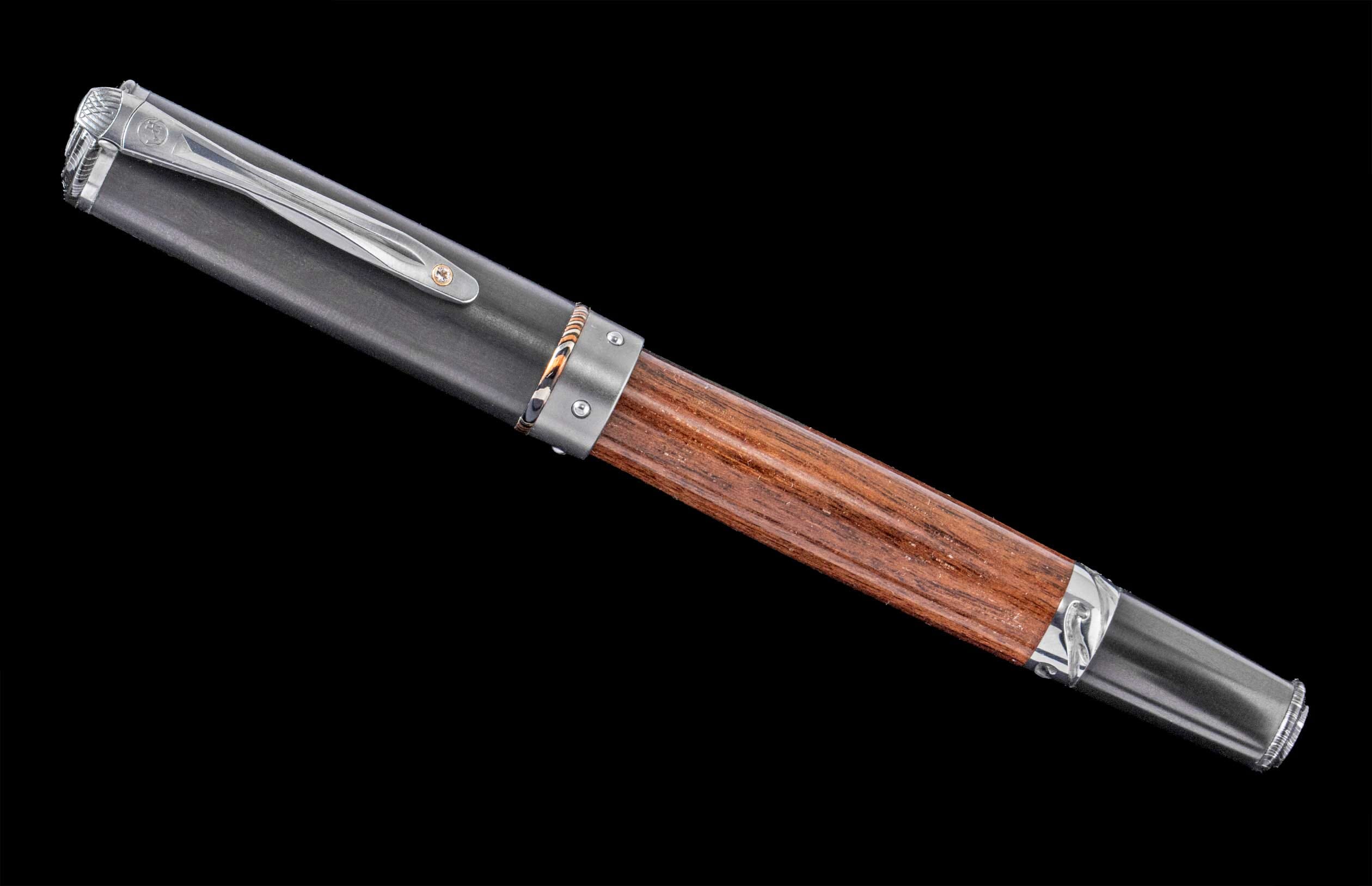 Handcrafted William Henry pen featuring a barrel of cherry wood from Churchill Downs Turf Club, titanium, aluminum, and a white topaz gemstone.