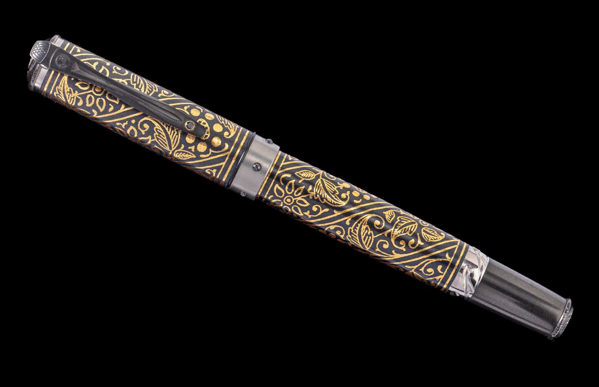 Handcrafted William Henry pen with 24K gold koftgari, hand-forged damascus and carbon fiber accents and a spinel gem stone. 