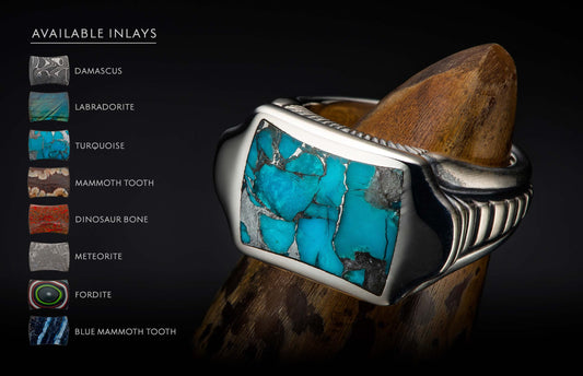 Silver ring with a large, fractured turquoise inlay and textured sides, displayed on a wooden stand.