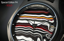 Special Edition Fordite watch by William Henry featuring multicolored striped dial with black, white, red, and orange layers, textured finish, and triangular hour markers in close-up view