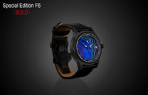 Special Edition Fordite watch by William Henry with vibrant blue and red marbled dial, black matte case, and black leather strap with tan lining, side view.