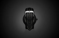 Special Edition Fordite watch with black leather strap and white stitching, featuring a polished silver buckle and textured case back, shown from rear view on dark gradient background.